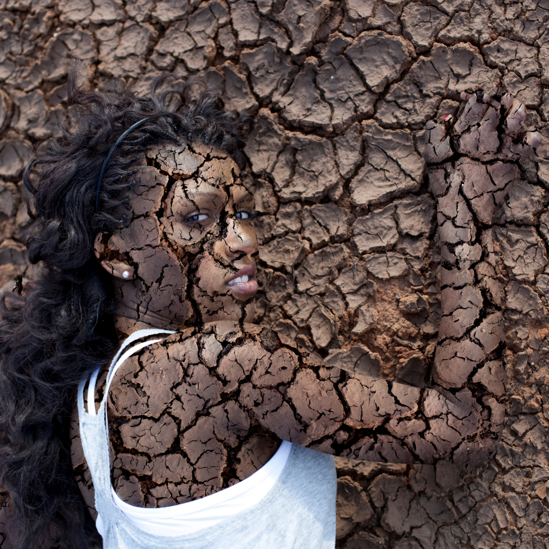 African american lady skin with dry skin that blends into a cracked up back ground