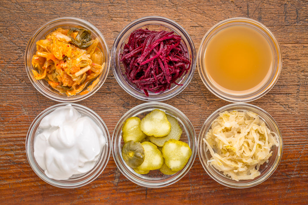 Six gut-healthy fermented foods including sauerkraut, pickles, and other probiotic-rich ingredients