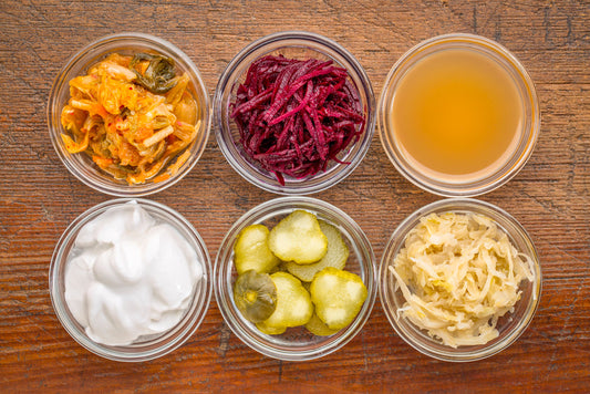 Six gut-healthy fermented foods including sauerkraut, pickles, and other probiotic-rich ingredients